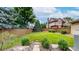 Large grassy backyard surrounded by a wood fence, rocks and lots of trees at 5723 S Kittredge St, Centennial, CO 80015