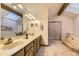 Bright bathroom featuring a double vanity, skylight, and separate shower and tub at 5723 S Kittredge St, Centennial, CO 80015