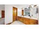 Bathroom with double sink vanity, warm wood cabinets, large mirror, and views to the adjacent living space at 5723 S Kittredge St, Centennial, CO 80015