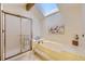 Bathroom featuring a skylight, a shower, and a soaking tub at 5723 S Kittredge St, Centennial, CO 80015