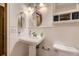Charming bathroom featuring a pedestal sink, white wainscoting, and classic fixtures for a clean, fresh feel at 5723 S Kittredge St, Centennial, CO 80015