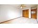Large bedroom with a ceiling fan, carpet, and wood closet doors at 5723 S Kittredge St, Centennial, CO 80015