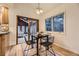 Bright dining area featuring modern lighting, wood floors, and sliding door access to a charming sunroom at 5723 S Kittredge St, Centennial, CO 80015