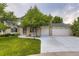 Charming two-story brick home with a well-maintained lawn, mature trees, and a spacious three-car garage at 5723 S Kittredge St, Centennial, CO 80015