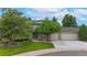 Beautiful home with a three-car garage, mature trees, and green lawn at 5723 S Kittredge St, Centennial, CO 80015