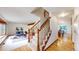 Hallway showcasing hardwood floors and a carpeted staircase leading to the living room and dining area at 5723 S Kittredge St, Centennial, CO 80015
