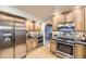 Updated kitchen boasting stainless steel appliances, wood cabinets, stone backsplash, and hardwood floors at 5723 S Kittredge St, Centennial, CO 80015