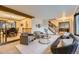 Open-concept living room showcasing large windows, wood beams, stylish seating, and connected dining area at 5723 S Kittredge St, Centennial, CO 80015