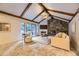 Light-filled living room with vaulted ceilings, exposed beams, stone fireplace, and sliding glass doors to backyard at 5723 S Kittredge St, Centennial, CO 80015