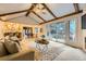 Open-concept living room flows into dining area with vaulted ceiling, exposed beams, and large sliding doors at 5723 S Kittredge St, Centennial, CO 80015