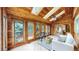 Cozy sunroom featuring wood paneling, skylights, tile flooring, and large windows overlooking the yard at 5723 S Kittredge St, Centennial, CO 80015