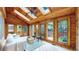Cozy sunroom featuring wood paneling, skylights, tile flooring, and large windows overlooking the yard at 5723 S Kittredge St, Centennial, CO 80015