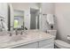 Bright bathroom with white vanity, sink, mirror and a glass door shower at 2154 S Parfet Dr, Lakewood, CO 80227