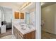 Bathroom featuring double sinks, a large mirror, and views into bedroom at 2154 S Parfet Dr, Lakewood, CO 80227