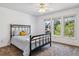 Bright bedroom features a black metal bed frame, ceiling fan, and large windows with views of the outdoors at 2154 S Parfet Dr, Lakewood, CO 80227