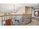 Foyer overlook with wood railing and chandelier at 2154 S Parfet Dr, Lakewood, CO 80227
