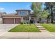 Charming two-story home with a well-manicured lawn, beautiful landscaping, and a spacious three-car garage at 2154 S Parfet Dr, Lakewood, CO 80227