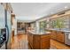 Open kitchen featuring an island, stainless appliances, and hardwood flooring at 2154 S Parfet Dr, Lakewood, CO 80227