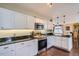 Well-lit kitchen features stainless steel appliances, black countertops and white cabinets at 8345 Moore St, Arvada, CO 80005