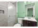 Modern bathroom features a marble tiled shower with glass doors, dark vanity, and matching mirror at 3680 S Beeler St # 5, Denver, CO 80237