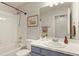 This bathroom features a shower over tub combination with white subway tile and a blue vanity with a white countertop at 3680 S Beeler St # 5, Denver, CO 80237