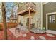 Private outdoor patio with chairs and table, red mulch and stone landscaping, and a view of the neighboring buildings at 3680 S Beeler St # 5, Denver, CO 80237