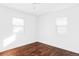 Simple bedroom with hardwood floors and two bright windows at 657 Newton St, Denver, CO 80204