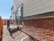 Back exterior of a townhome with brick and siding, a gravel area, and a sliding glass door for entry at 383 Remuda Rd, Berthoud, CO 80513