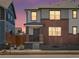 Charming two-story home with gray siding, brick accents, and a well-manicured front yard under a lovely colorful sunset sky at 383 Remuda Rd, Berthoud, CO 80513