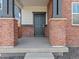 Welcoming front porch with classic brick columns, dark trim, and a stylish entrance door for a warm first impression at 383 Remuda Rd, Berthoud, CO 80513