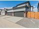 Modern townhome with attached garages, featuring gray doors, brick accents, and concrete driveways at 383 Remuda Rd, Berthoud, CO 80513