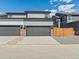 Modern townhome with attached garages, featuring gray doors, brick accents, and concrete driveways at 383 Remuda Rd, Berthoud, CO 80513