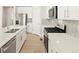 Contemporary kitchen featuring stainless steel appliances, white cabinets, and a stylish backsplash at 383 Remuda Rd, Berthoud, CO 80513