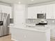 Modern kitchen features stainless steel appliances, white cabinetry, and a large quartz island at 383 Remuda Rd, Berthoud, CO 80513