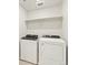 Clean, well-lit laundry room featuring a modern washer and dryer with shelving for easy access to supplies at 383 Remuda Rd, Berthoud, CO 80513