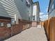 Side exterior of a townhome with brick and siding, a gravel area, and a privacy fence at 383 Remuda Rd, Berthoud, CO 80513