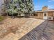 Brick patio and exterior of the home with mature trees and landscaping in the backyard at 4365 S Alton Way, Greenwood Village, CO 80111