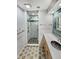 Modern bathroom features a glass-enclosed shower, custom cabinets, unique flooring, and artistic wall tiles at 4365 S Alton Way, Greenwood Village, CO 80111