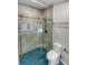 Bathroom featuring blue tiled floor, a toilet, and a glass shower with gold hardware at 4365 S Alton Way, Greenwood Village, CO 80111