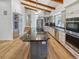 Open gourmet kitchen with island cooktop, stainless steel appliances, custom cabinets, granite counters, and vaulted ceilings at 4365 S Alton Way, Greenwood Village, CO 80111