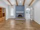 Living room with beamed vaulted ceilings, fireplace with brickwork, hardwood floors, and an archway to another room at 4365 S Alton Way, Greenwood Village, CO 80111