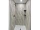 Close-up of a modern tiled shower with a built-in niche, shelves, and rainfall showerhead at 4365 S Alton Way, Greenwood Village, CO 80111