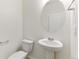 Clean bathroom features a pedestal sink, oval mirror, and white fixtures at 9872 Cathay St, Commerce City, CO 80022