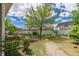 Backyard with a stone path, lush green grass, and privacy fence at 5403 Odessa St, Denver, CO 80249
