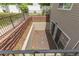 A walkout basement featuring sliding glass doors with small gravel yard, concrete wall, and sturdy black metal railings at 5403 Odessa St, Denver, CO 80249
