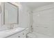 Bright bathroom with white cabinets, quartz countertop, framed mirror and a shower over tub at 5403 Odessa St, Denver, CO 80249