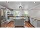 Bright kitchen with stainless steel appliances, center island, granite counters, and mosaic tile backsplash at 5403 Odessa St, Denver, CO 80249