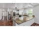 Open kitchen features stainless steel appliances, granite counters, mosaic backsplash, and hardwood floors at 5403 Odessa St, Denver, CO 80249
