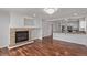 Open-concept living room featuring gleaming hardwood floors, fireplace, and kitchen access at 5403 Odessa St, Denver, CO 80249