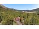 Stunning aerial view of a secluded home nestled among lush trees and mountains in a beautiful landscape at 25531 Mosier Cir, Conifer, CO 80433